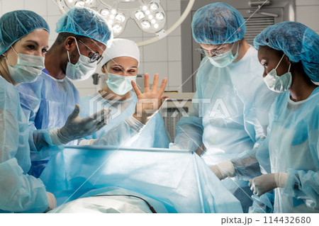 the patient is waking up while surgeons is making a small incision, 114432680