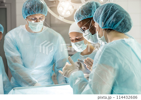 doctors and nurses providing treatment through an opening in the body. 114432686