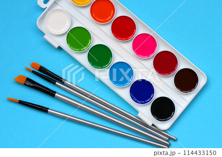 paint brushes and watercolor paints on a blue background. the concept of back to school paint brushes and watercolor paints on a blue background. the concept of back to school 114433150
