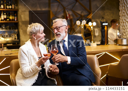 I like you. Sweet cheerful senior couple having date in restaurant while smiling and clink glasses I like you. Sweet cheerful senior couple having date in restaurant while smiling and clink glasses 114433151