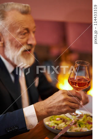 Senior elegant man with glass of red wine in restaurant 114433319