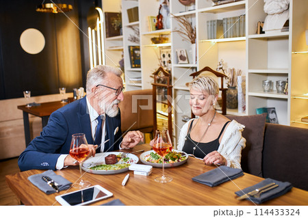 Mature couple having dinner at cafe Mature couple having dinner at cafe 114433324