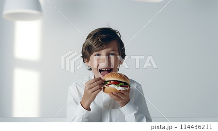 The image shows a boy eating a hamburger The topic could beA boy 114436211
