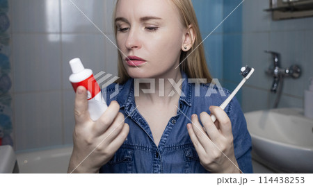 Toothpaste ingredients. Girl checks composition of toothpaste and is surprised by dangerous composition of product. Emulsifiers, preservatives, dyes, PEG, SLS, parabens, diethanolamine 114438253