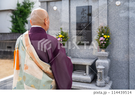 永代供養墓の前で読経するお坊さん 114439514