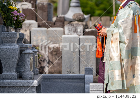 永代供養墓の前で読経するお坊さん 114439522