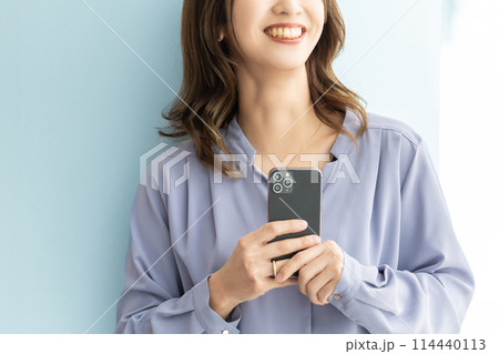 スマートフォンを持つ笑顔の日本人ビジネスウーマン 114440113