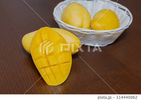 Mango fruit and mango cubes on the wooden table Mango fruit and mango cubes on the wooden table 114440862