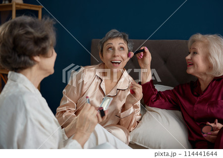 Funny old woman friends wearing pajamas doing makeup 114441644