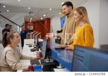 Man and woman couple talking to receptionist at family clinic center Man and woman couple talking to receptionist at family clinic center 114441768