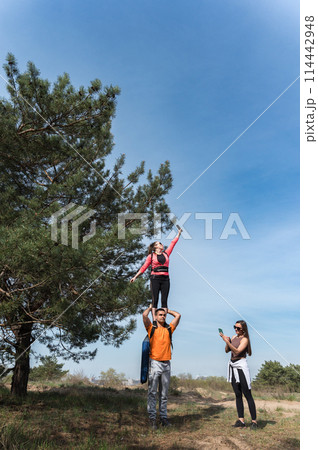 Tourists catching cellular network signal in forest. 114442948