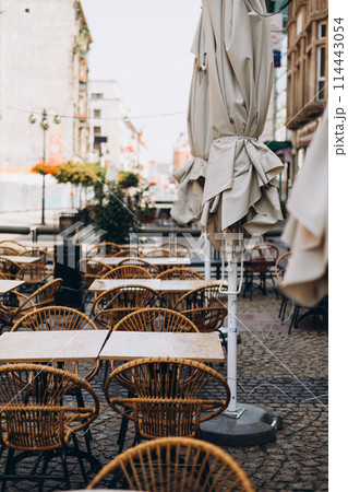 Outdoor street cafe tables ready for service. Modern Empty cafe terrace with table and chair, morning time. Food concept. Cafeteria, Outside Trattoria 114443054