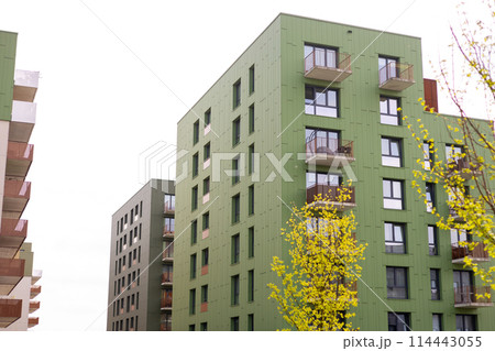 Modern apartment buildings on a sunny summer day. Green Facade of a modern apartment complex. Living house facade with balconies. Mortgage in real estate 114443055