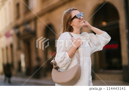 Young beautiful woman walking the streets of an Italian town. Travel and tourism concept. Young beautiful woman walking the streets of an Italian town. Travel and tourism concept. 114443141