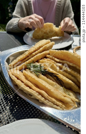 At the picnic, delicious hot chebureks with meat are prepared for tasting At the picnic, delicious hot chebureks with meat are prepared for tasting 114444103