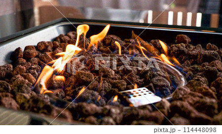 Stone firepit with fire flames. Summer camping bonfire. Stone firepit with fire flames. Summer camping bonfire. 114448098