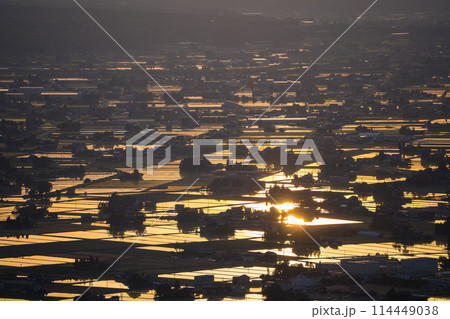 水が張られた田んぼに美しく反射する太陽の夕景|散居村展望広場より撮影|富山県砺波市 水が張られた田んぼに美しく反射する太陽の夕景|散居村展望広場より撮影|富山県砺波市 114449038