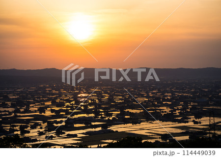 水が張られた田んぼに美しく反射する太陽の夕景|散居村展望広場より撮影|富山県砺波市 水が張られた田んぼに美しく反射する太陽の夕景|散居村展望広場より撮影|富山県砺波市 114449039