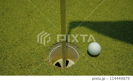 Golf ball is on a green lawn in a beautiful golf course with morning sunshine. Golf ball is on a green lawn in a beautiful golf course with morning sunshine. 114449879