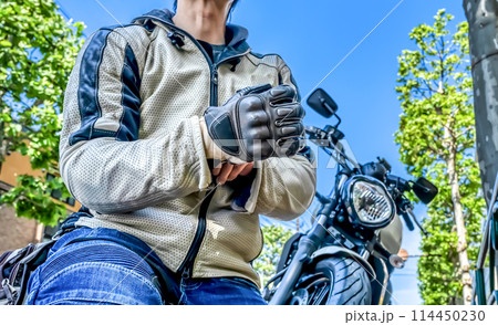 バイク用ライディンググローブを準備する男性ライダー バイク用ライディンググローブを準備する男性ライダー 114450230