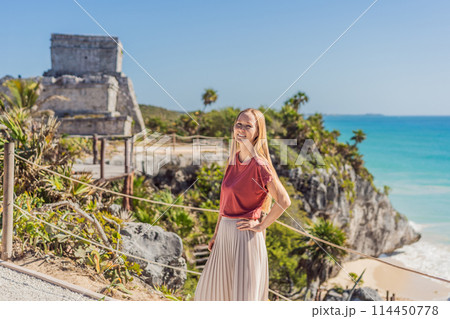 Woman tourist enjoying the view Pre-Columbian Mayan walled city of Tulum, Quintana Roo, Mexico, North America, Tulum, Mexico. El Castillo - castle the Mayan city of Tulum main temple 114450778