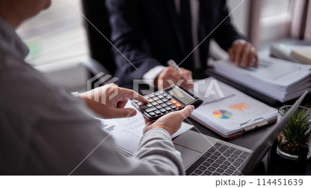 Two businessman real estate seller calculating about property investment and showing statistic on calculator while discussion about home sales contract and home insurance to taking notes in paper Two businessman real estate seller calculating about property investment and showing statistic on calculator while discussion about home sales contract and home insurance to taking notes in paper 114451639
