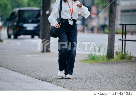 時間を気にしながら歩く若い女性 114454035