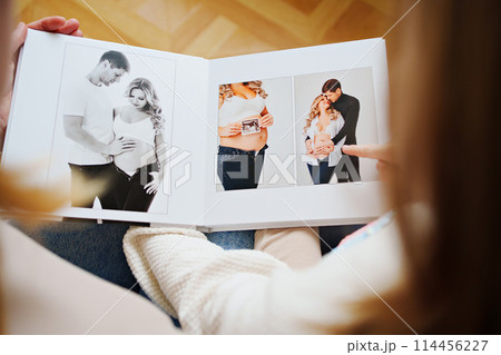 mother and daughter flips through a book with photos of dad and pregnant mom. mother and daughter flips through a book with photos of dad and pregnant mom. 114456227