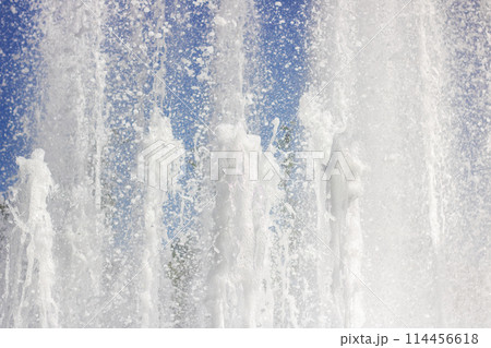 Water fountain splashing liquid against an electric blue sky Water fountain splashing liquid against an electric blue sky 114456618
