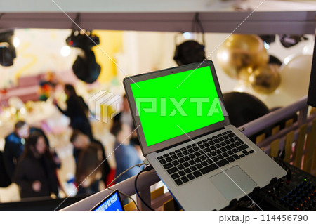 Laptop with blank green screen on party background.  114456790