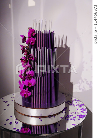 Large and beautiful purple three-tiered cake with flowers. Large and beautiful purple three-tiered cake with flowers. 114456973