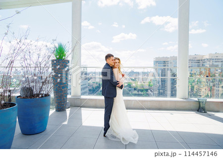 Happy bride and groom on the terrace of a multi-storey hotel. 114457146