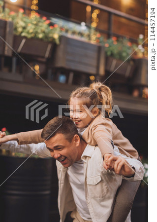 Dad and teenage daughter having fun on a walk in the city.  114457194