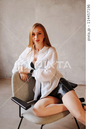 Portrait of sexy redhead young woman in white shirt on a chair. Portrait of sexy redhead young woman in white shirt on a chair. 114457196