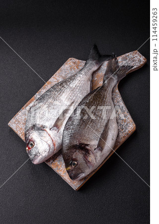 Whole raw dorado fish with lemon, salt, spices and herbs 114459263