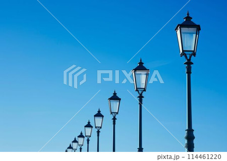 Row of Street Lamps Against a Clear Blue Sky. Generative ai 114461220