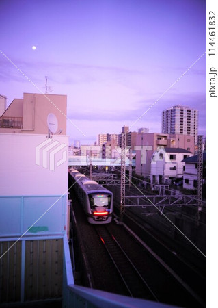 夕暮れの線路を走る電車 114461832