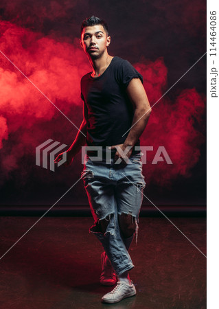 Single young man dancer wearing jeans showing various steps isolated in smoky studio Single young man dancer wearing jeans showing various steps isolated in smoky studio 114464086