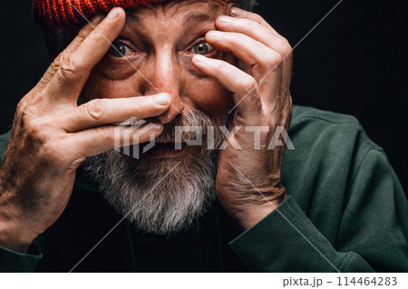 An elderly man looking extremely frightened, protecting his face with hands. An elderly man looking extremely frightened, protecting his face with hands. 114464283