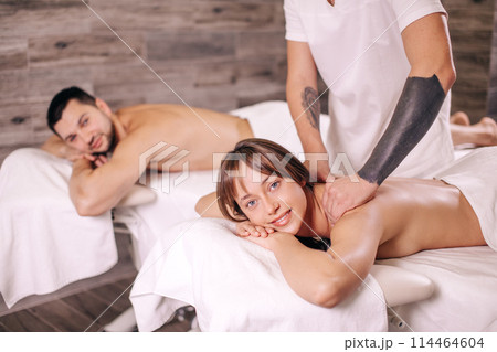 young girl and her boyfriend are looking at camera while getting neck massage 114464604