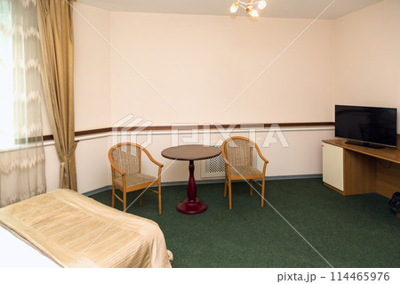 Spacious hotel room with furniture and green carpet on the floor Spacious hotel room with furniture and green carpet on the floor 114465976