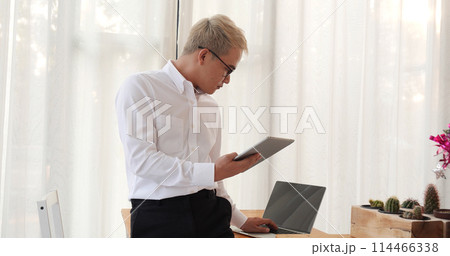 Business colleague working together using smartphone searching website and blogs for business news in conference room. Asian young man wear suit and tide formal dress waiting meeting. Business concept Business colleague working together using smartphone searching website and blogs for business news in conference room. Asian young man wear suit and tide formal dress waiting meeting. Business concept 114466338