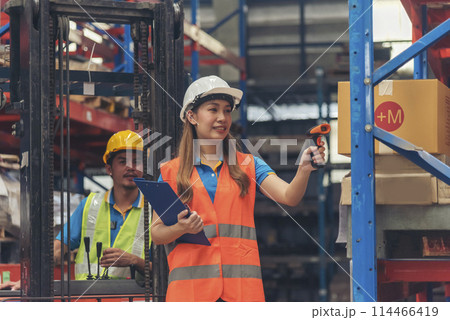 Warehouse management team use bar code scaner scan goods shelf writing checklist on clipboard. Asian men women worker check stock inventory. Teamwork logistics staff counting products store inventory 114466419