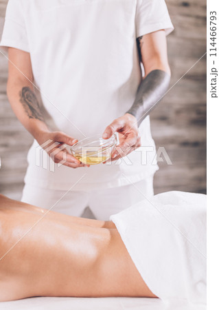 man is going to massage female's body with oil man is going to massage female's body with oil 114466793
