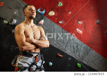 Portrait of cheerful rock climber in indoor climbing gym 114467635