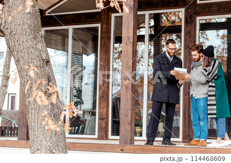 Young couple with real estate agent near house, purchase or rent concept Young couple with real estate agent near house, purchase or rent concept 114468609