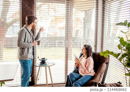 Young couple spending morning in new home, discussing their plans for future Young couple spending morning in new home, discussing their plans for future 114468662