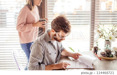 Happy couple checking bank account on line in a tablet sitting on a couch in the living room at home Happy couple checking bank account on line in a tablet sitting on a couch in the living room at home 114468721