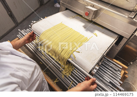 Pasta through a roller machine Pasta through a roller machine 114469175