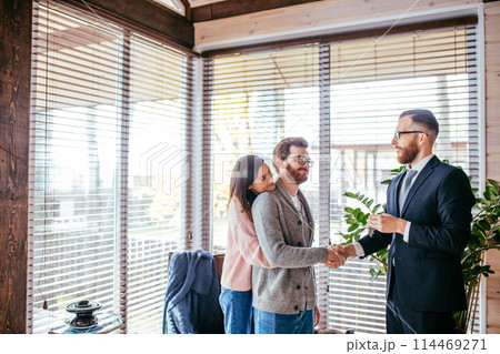 Couple customers signing papers with mortgage broker making purchase deal 114469271